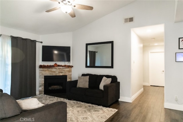 living room featuring lofted ceiling, ceiling fan, a fireplace, and dark wood-type flooring