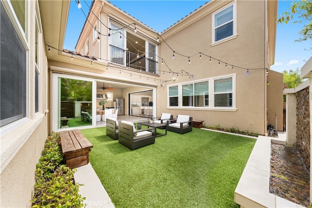 rear view of house with outdoor lounge area, a balcony, and a lawn