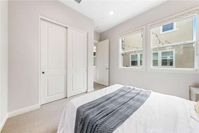 bedroom featuring light carpet and a closet