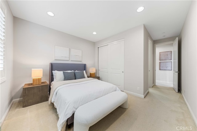 bedroom featuring light colored carpet and a closet