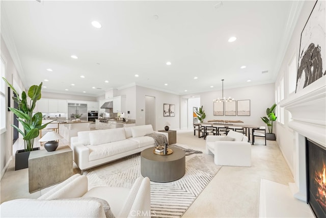 carpeted living room with a notable chandelier and ornamental molding