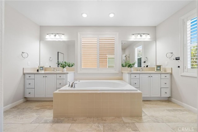 bathroom with tiled tub and vanity