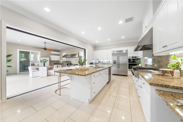 kitchen featuring tasteful backsplash, a large island, stainless steel appliances, and light stone counters