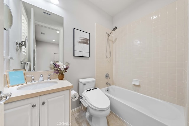 full bathroom featuring tile patterned floors, vanity, tiled shower / bath combo, and toilet