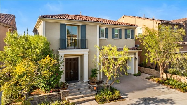 mediterranean / spanish home featuring a balcony and a garage