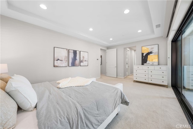 carpeted bedroom with a raised ceiling