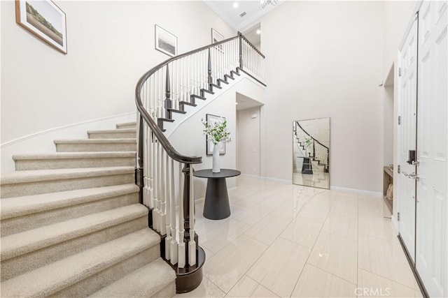 staircase featuring tile patterned floors and a high ceiling