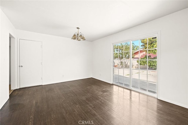 spare room with wood-type flooring and a notable chandelier