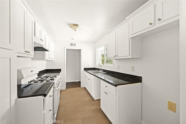 kitchen featuring white cabinets, light hardwood / wood-style floors, white gas range, and sink