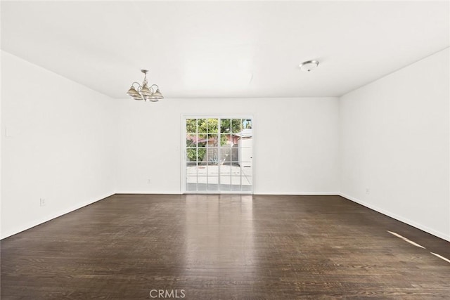 unfurnished room with dark wood-type flooring and a notable chandelier