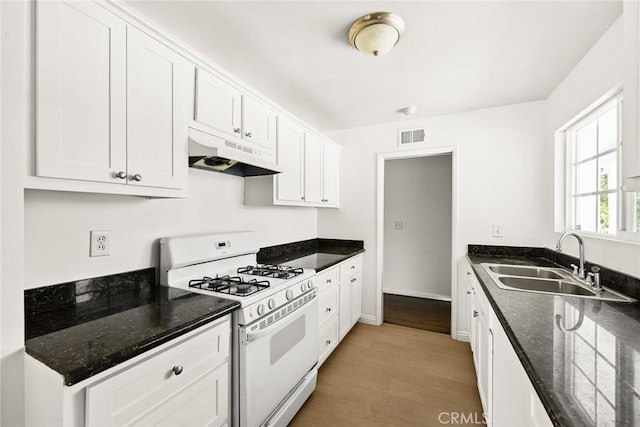 kitchen featuring sink, white cabinetry, white gas range oven, and light hardwood / wood-style flooring