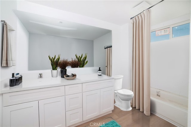 full bathroom with vanity, hardwood / wood-style flooring, shower / tub combo, and toilet