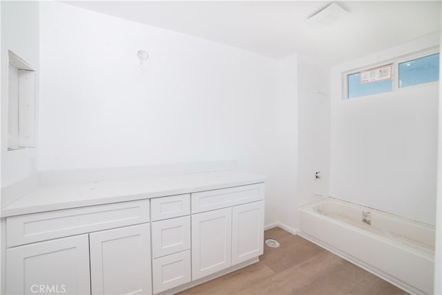 bathroom featuring a bath and hardwood / wood-style flooring