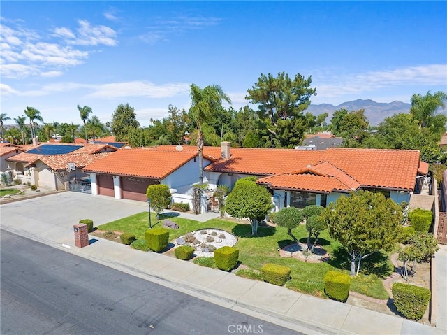 view of front of property with a mountain view, a garage, and a front yard