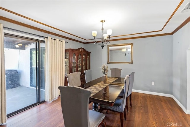 dining room featuring hardwood / wood-style floors, an inviting chandelier, and crown molding