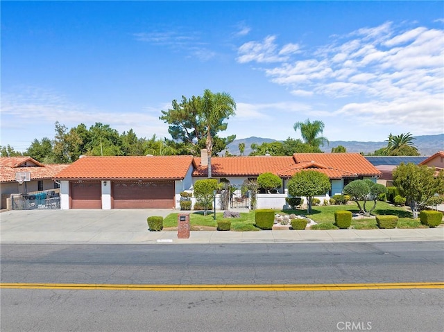 mediterranean / spanish-style home with a mountain view and a garage