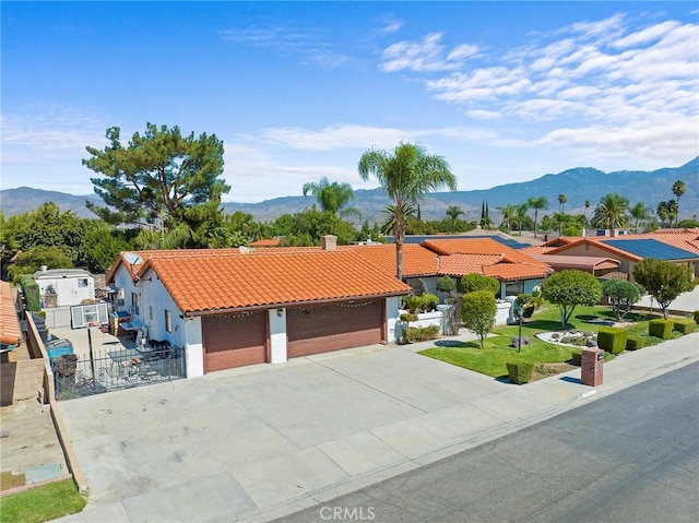 view of front of home with a mountain view, a garage, and a front yard