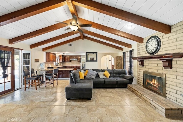 living room featuring a fireplace, vaulted ceiling with beams, ceiling fan, and wood ceiling