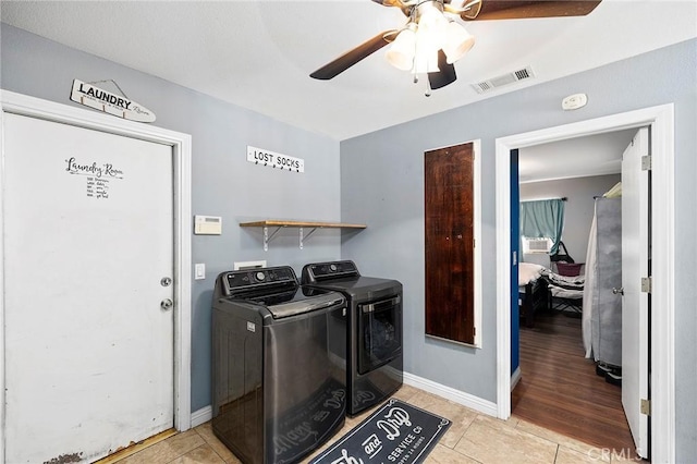 laundry room featuring ceiling fan, light hardwood / wood-style flooring, and washer and dryer