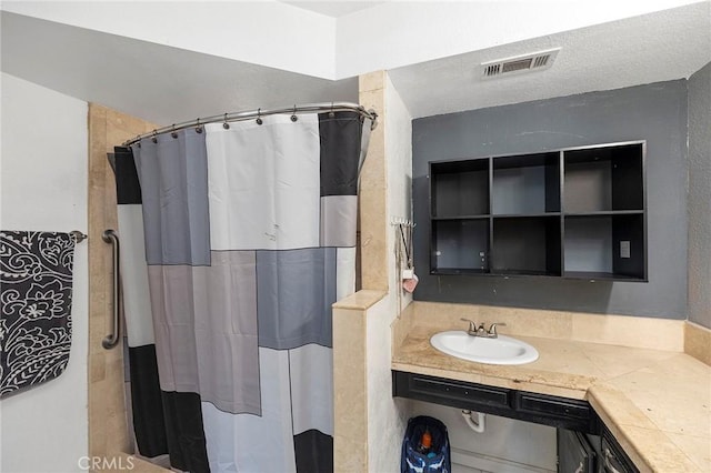 bathroom featuring a shower with shower curtain and sink