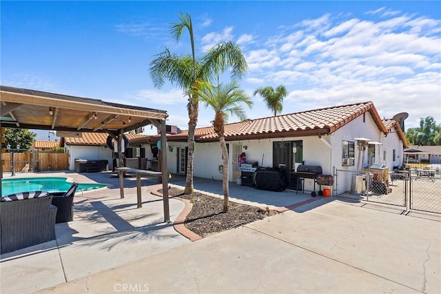 back of property with a patio area and a pool with hot tub