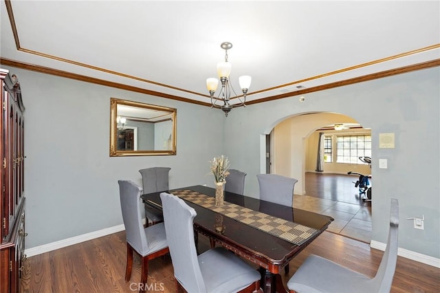 dining area featuring dark hardwood / wood-style flooring, a notable chandelier, and ornamental molding