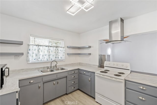 kitchen featuring sink, island exhaust hood, gray cabinets, light wood-type flooring, and white range with electric stovetop