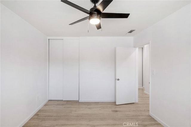 unfurnished bedroom with a closet, light wood-type flooring, and ceiling fan