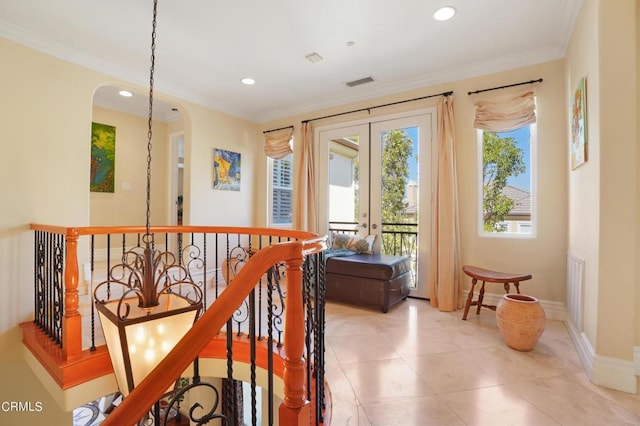 hallway with ornamental molding, french doors, and a healthy amount of sunlight