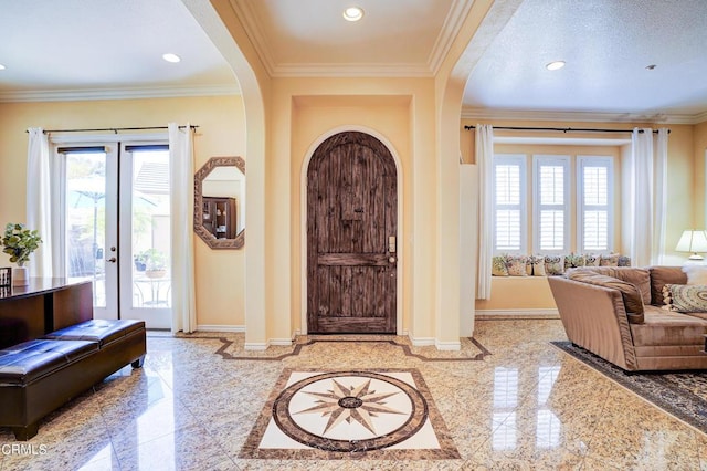 foyer featuring ornamental molding, a textured ceiling, and french doors