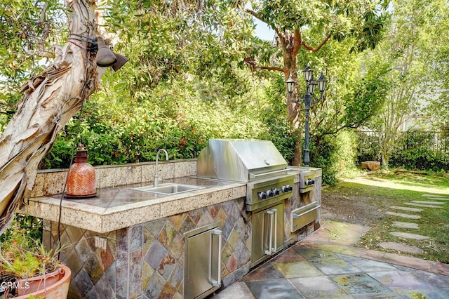 view of patio featuring an outdoor kitchen, a grill, and sink