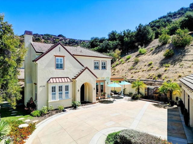 view of front of property with a patio area, a mountain view, and french doors