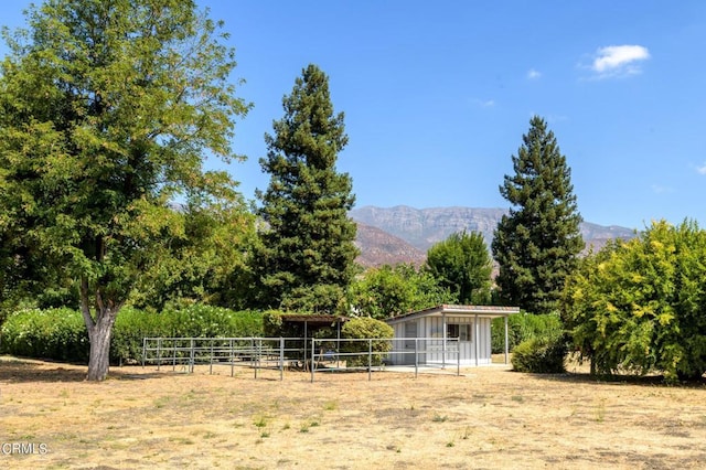 view of yard with a mountain view, a rural view, and an outbuilding