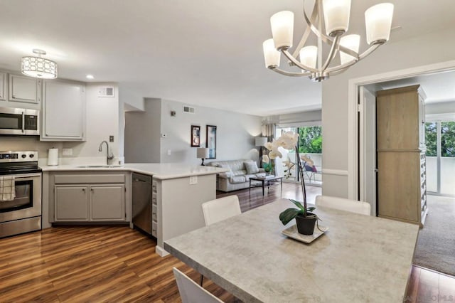 dining area featuring a chandelier, sink, and dark hardwood / wood-style floors