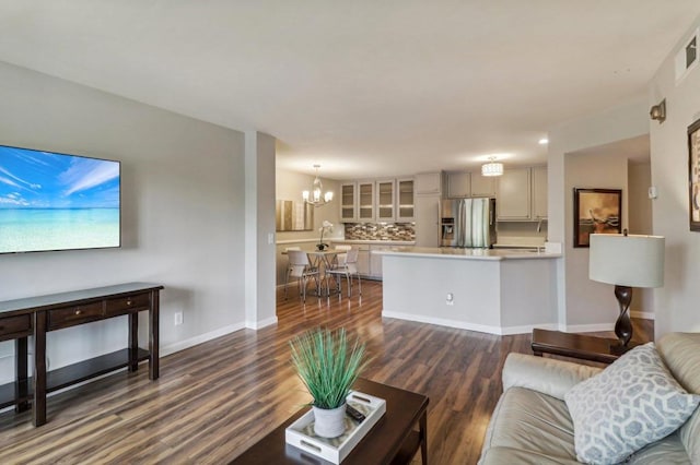 living room featuring a notable chandelier and dark hardwood / wood-style flooring