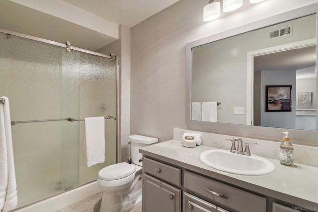 bathroom featuring walk in shower, vanity, and toilet