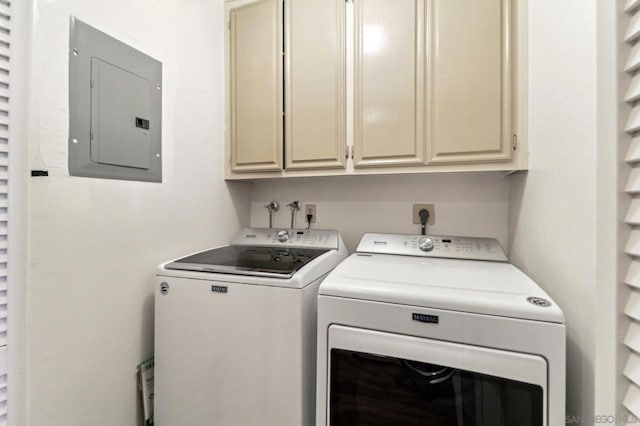 laundry area featuring electric panel, cabinets, and washing machine and clothes dryer