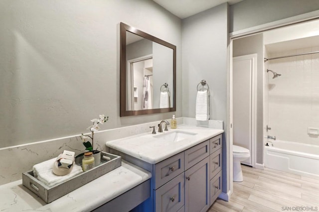 full bathroom featuring hardwood / wood-style flooring, vanity, toilet, and shower / washtub combination