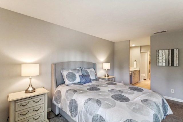 carpeted bedroom featuring connected bathroom