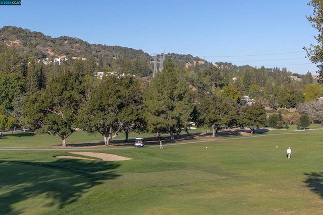 view of home's community with a mountain view and a lawn