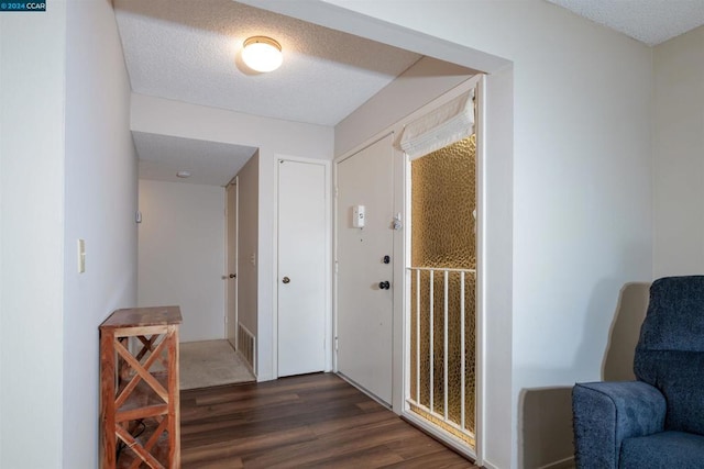 hallway featuring dark wood-type flooring and a textured ceiling