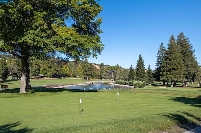 surrounding community featuring a lawn and a water view