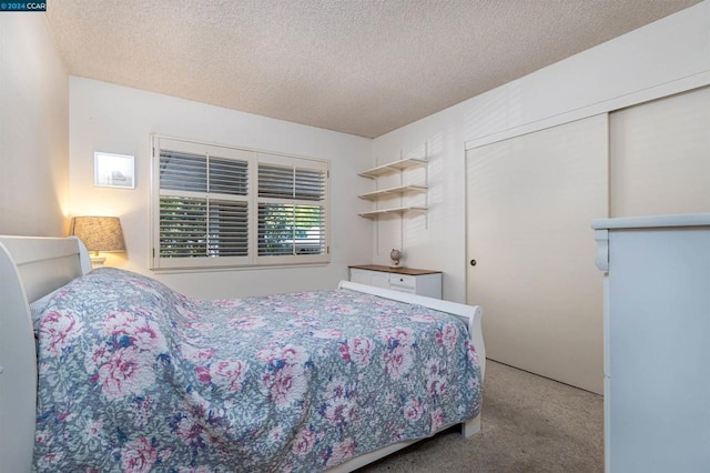 bedroom featuring a closet, carpet flooring, and a textured ceiling