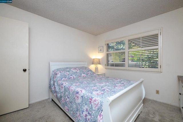 carpeted bedroom featuring a textured ceiling