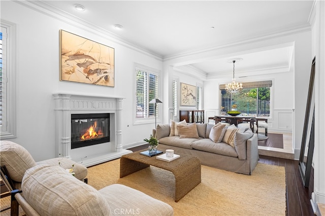 living room with hardwood / wood-style floors, crown molding, and a notable chandelier