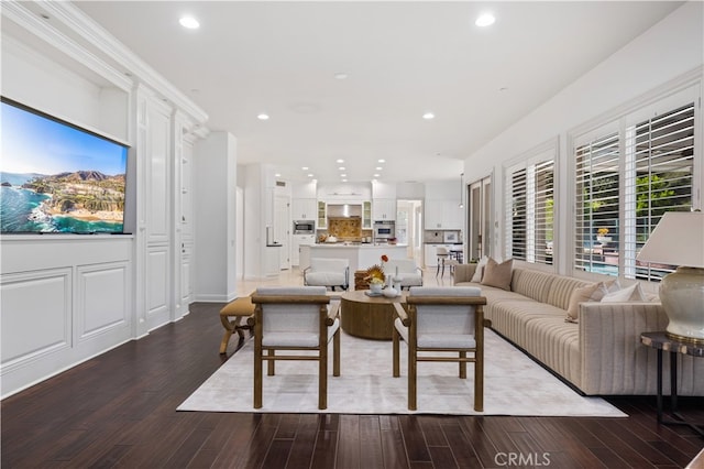 living room featuring a healthy amount of sunlight, wood-type flooring, and ornamental molding