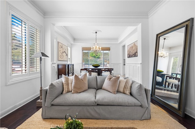 living room with dark hardwood / wood-style flooring, an inviting chandelier, and ornamental molding