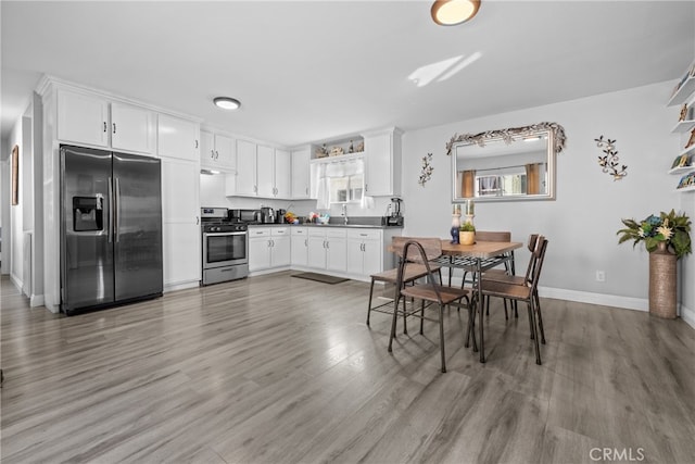 kitchen featuring stainless steel appliances, light wood-type flooring, sink, and white cabinetry