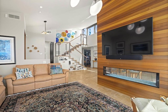 tiled living room with wood walls and a high ceiling