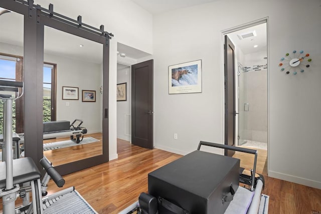 exercise area with hardwood / wood-style flooring and a barn door